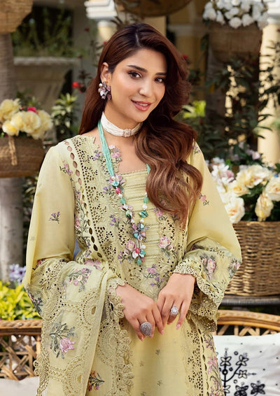 Woman in a light green embroidered outfit with floral patterns in an outdoor setting.